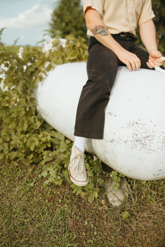 Man sitting outside on a propane tank