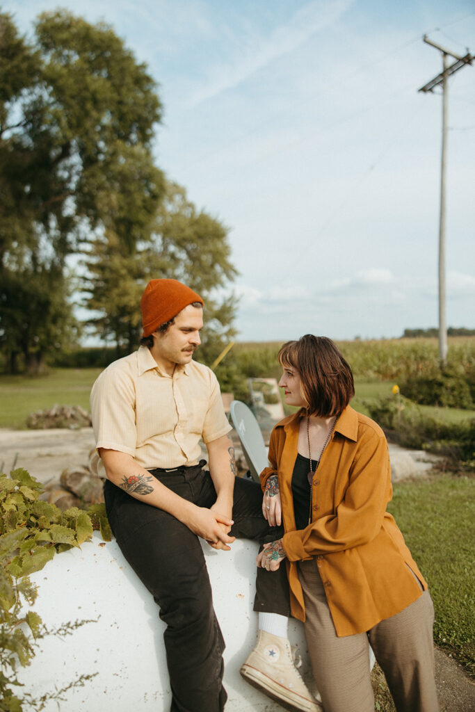 Couple posing against a propane tank outside during their at-home vintage couple photoshoot in Michigan