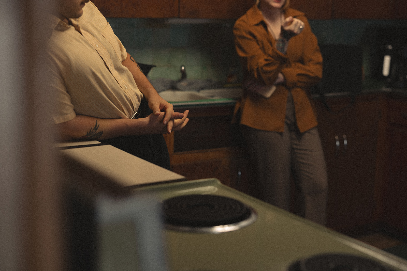 A candid photo of a couple standing in their Michigan kitchen during their at-home vintage couple photoshoot