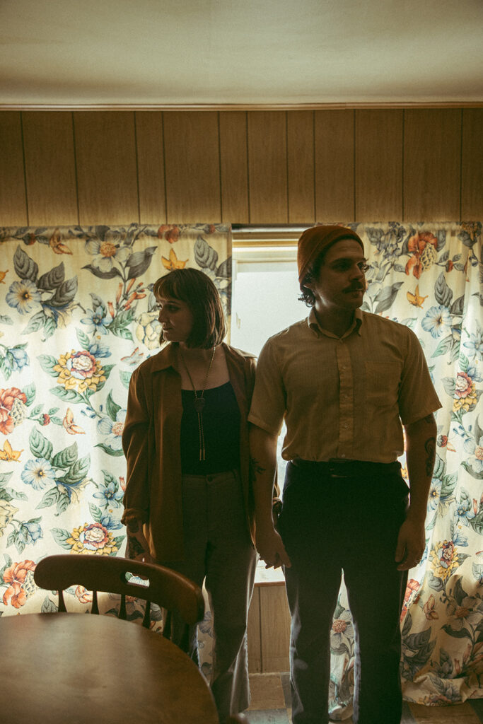 Man and woman posing for photos in a kitchen for their at-home vintage couple photoshoot