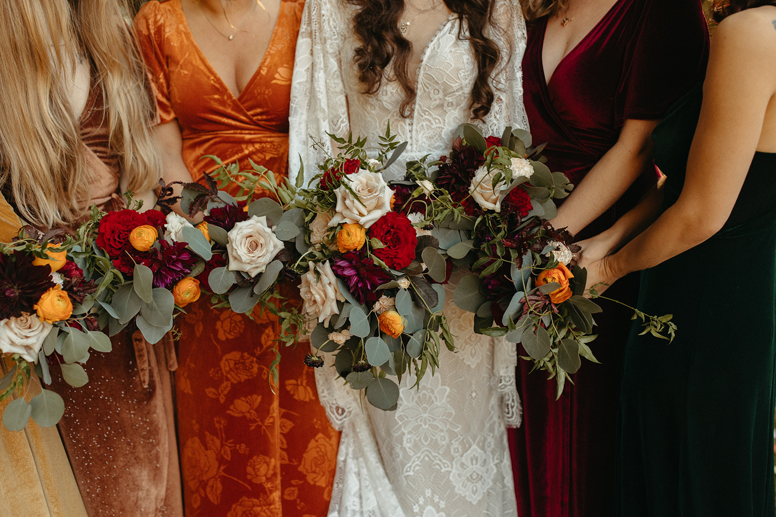 Bride and bridesmaids holding fall wedding bouquets