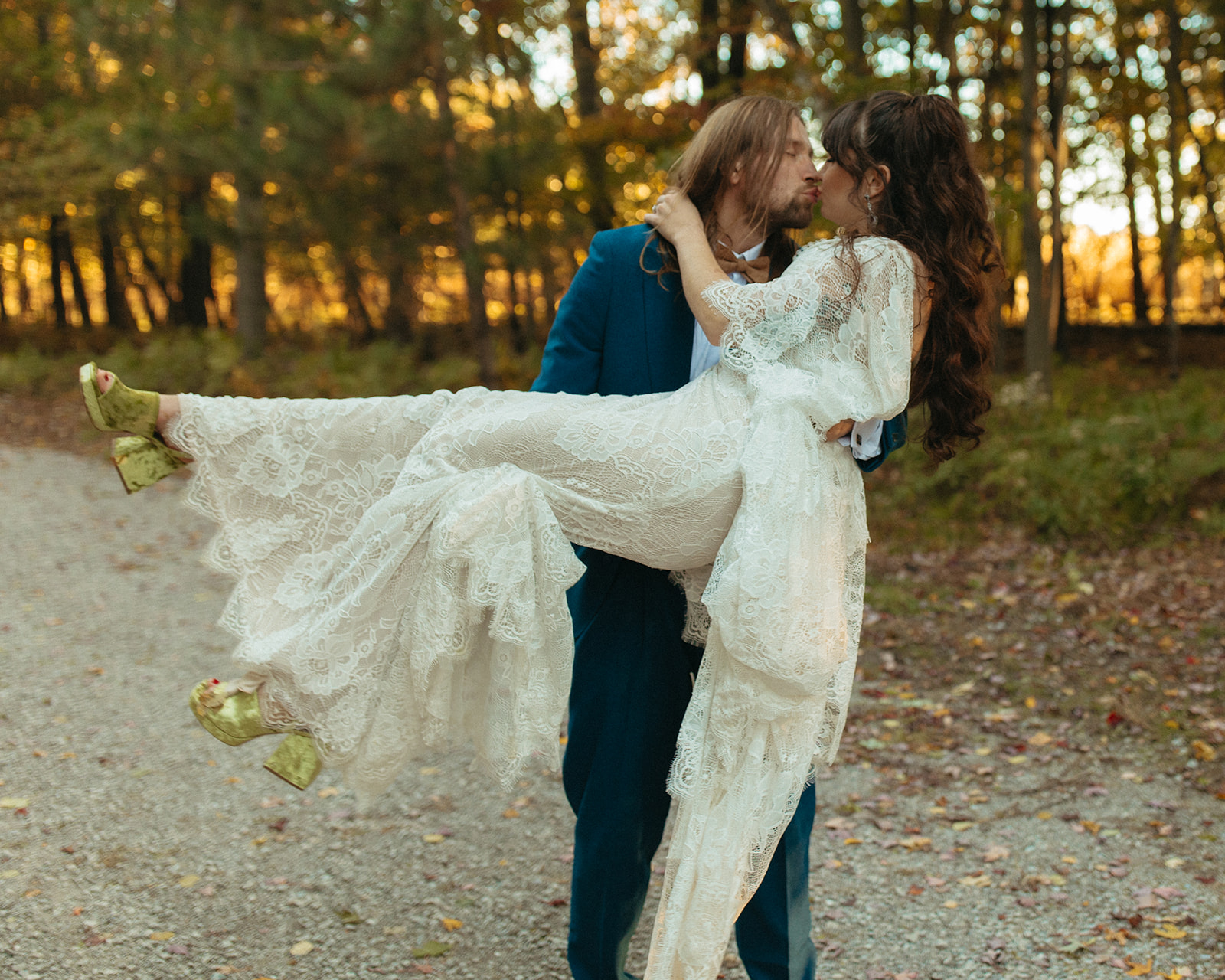 Groom lifting up his bride and kissing her for their outdoor wedding portraits