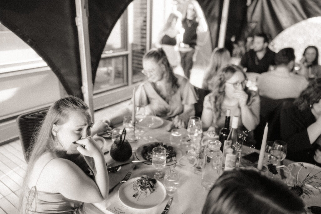 Black and white documentary wedding photo of guests getting emotional during reception speeches