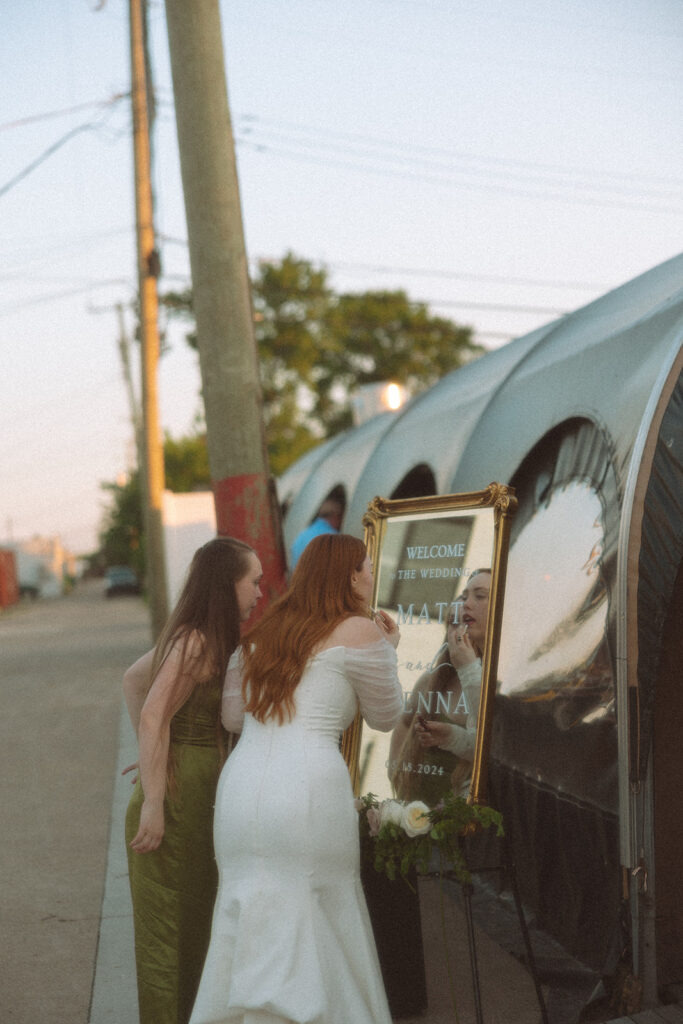 Bride touching up her makeup in the mirror