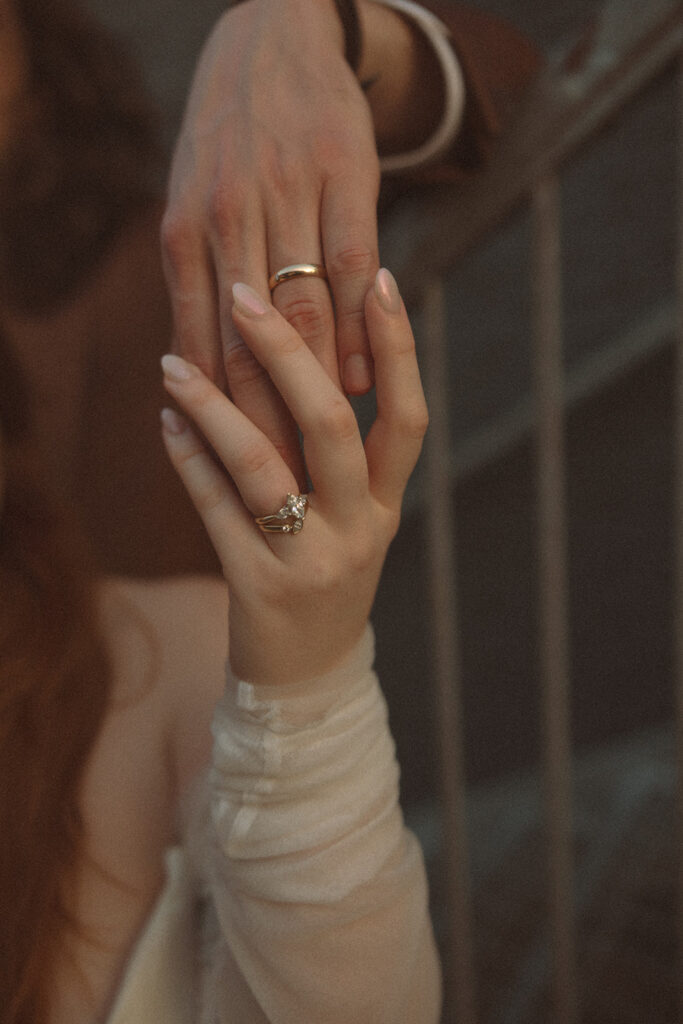 Close up detail shot of a bride and groom holding hands