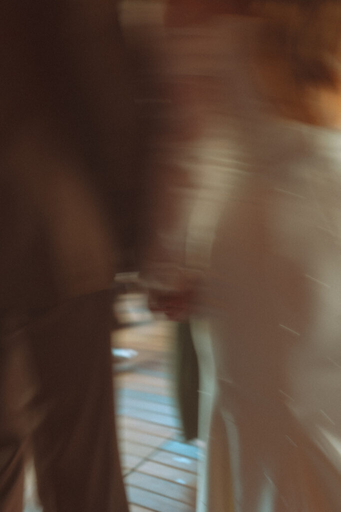 Blurry wedding photo of a bride and groom holding hands