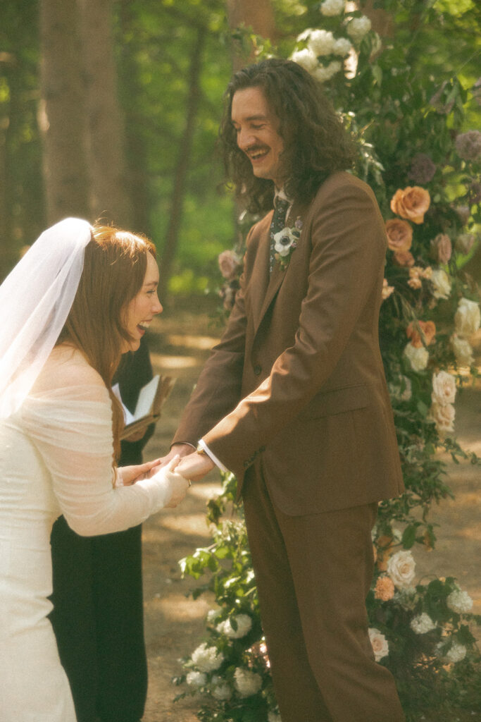 Bride and groom laughing during their Stony Creek Metropark wedding ceremony