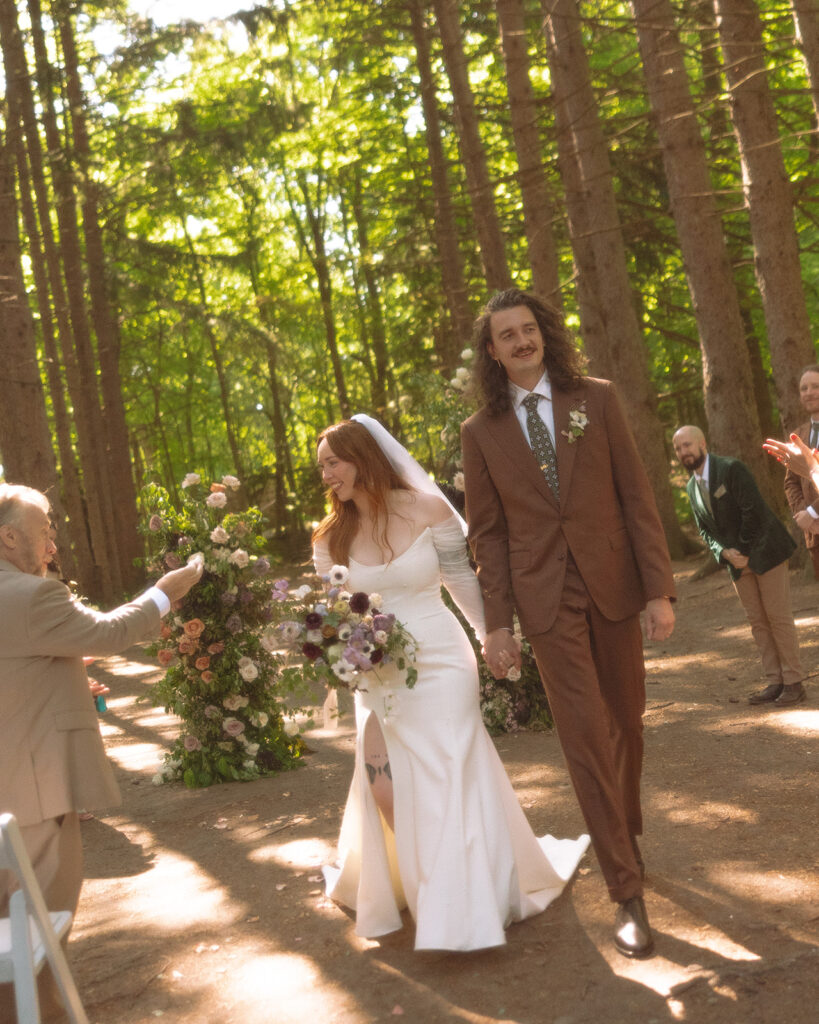 Bride and groom walking back down the aisle after their Stony Creek Metropark wedding ceremony