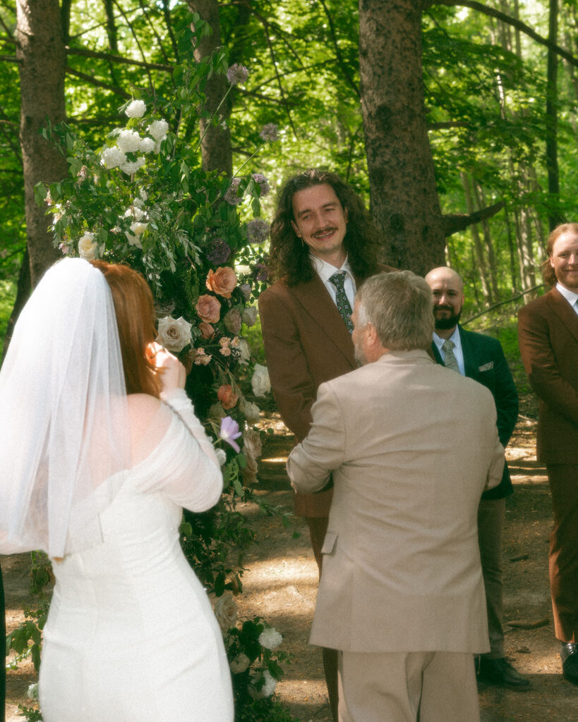 Father giving away his daughter at the altar during a Stony Creek Metropark wedding in Detroit, Michigan