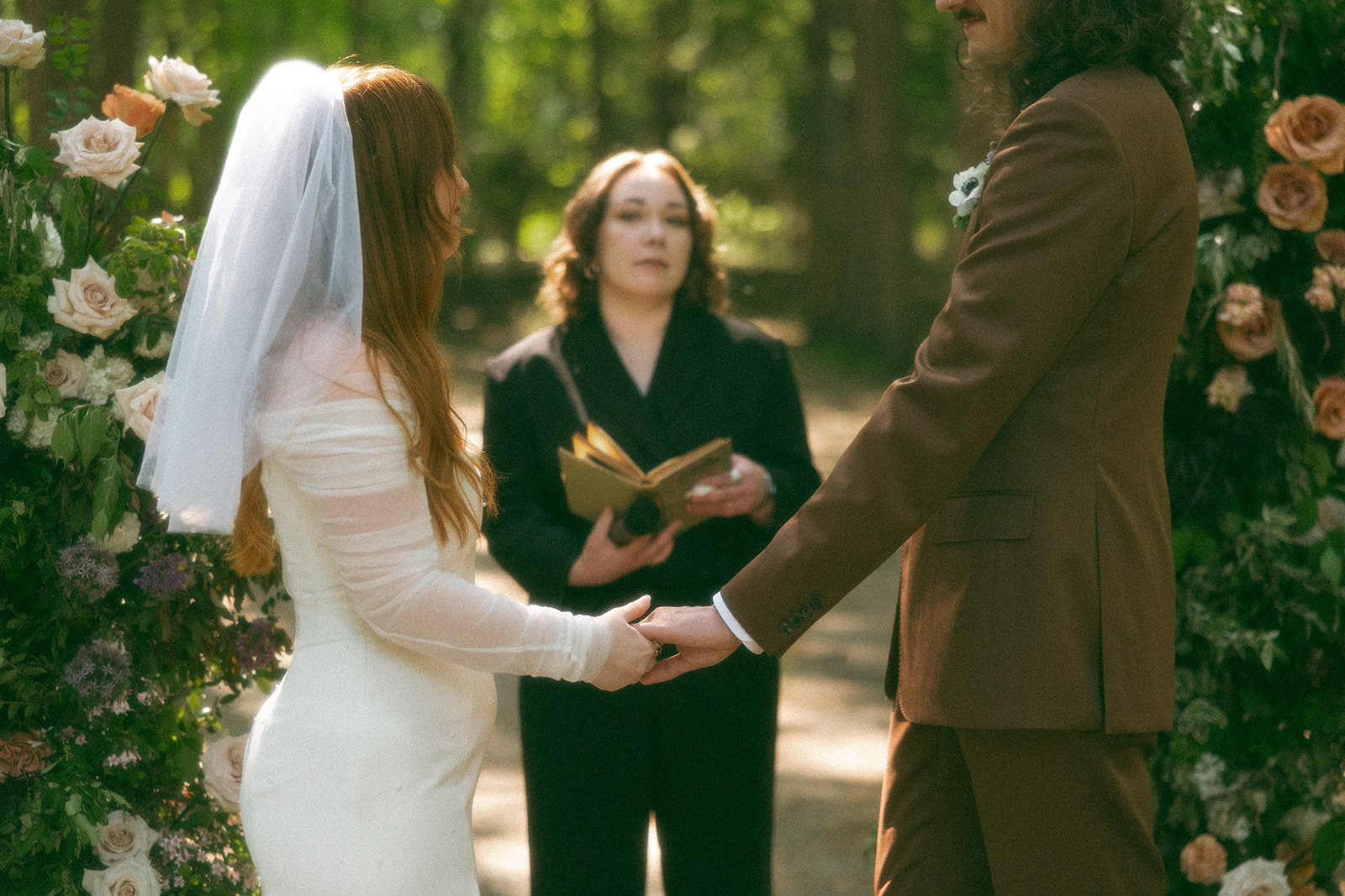 Bride and groom holding hands at the altar for their Stony Creek Metropark wedding in Detroit, Michigan