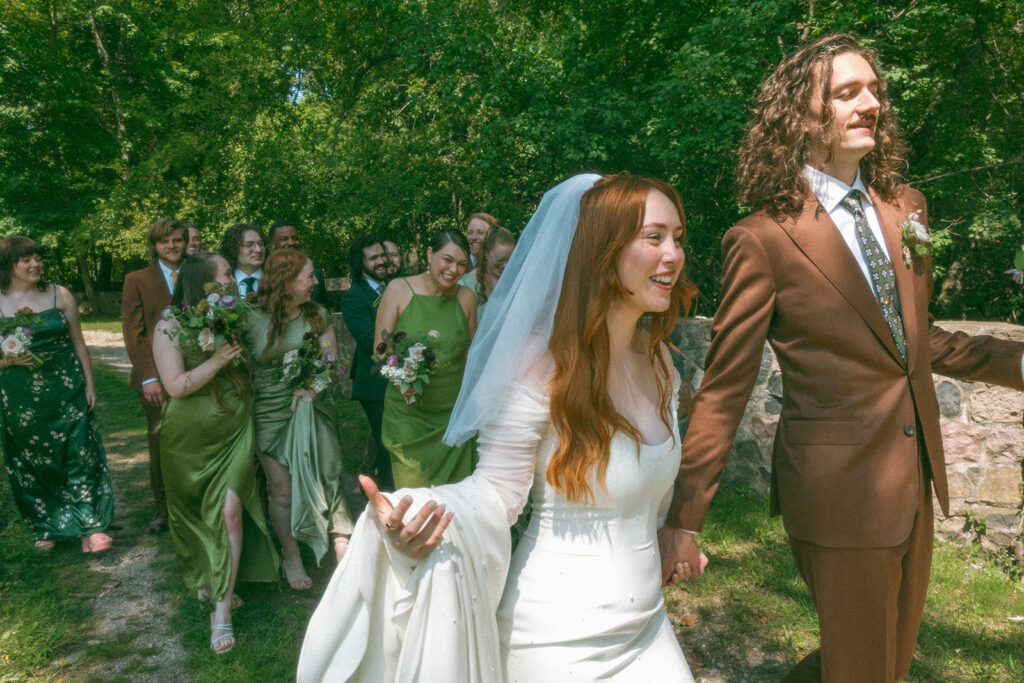 Bride and groom walking through Stony Creek Metropark in Detroit, Michigan