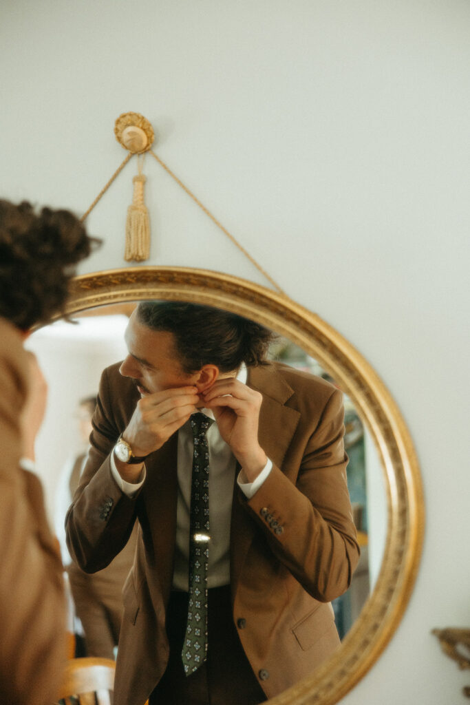 Groom putting his earrings in for his Detroit, Michigan wedding