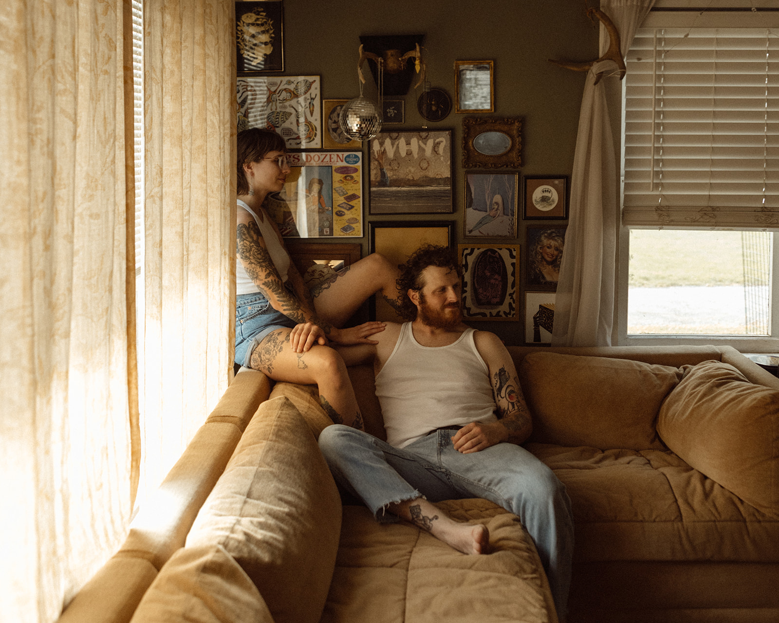 Couple sitting on their couch together for their at-home Grand Rapids engagement photos