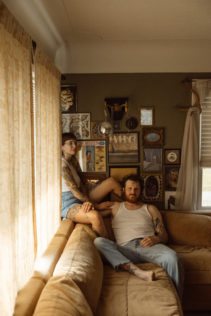 Man and woman sitting on their couch for their at-home Grand Rapids engagement photos