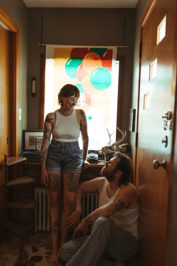 Couple sitting in their hallway during their at-home Grand Rapids engagement photos