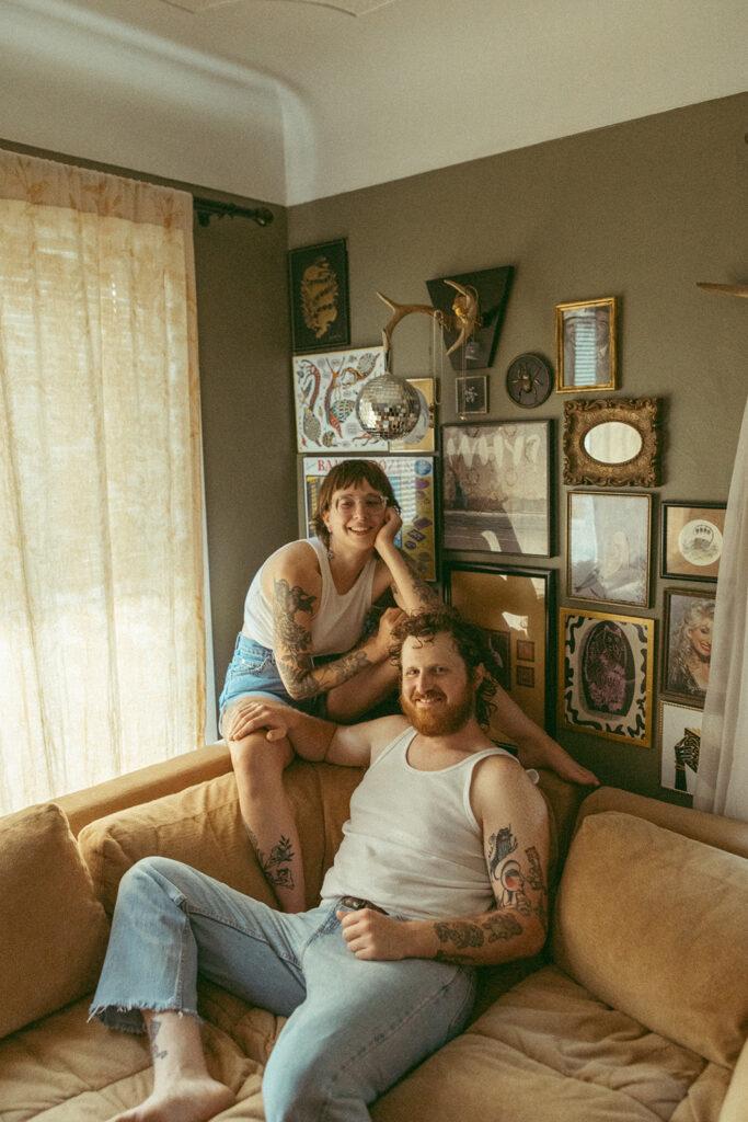 Couple sitting on their couch during their at-home Grand Rapids engagement photos