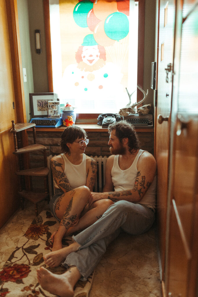 Couple sitting in their hallway during their at-home Grand Rapids engagement photos