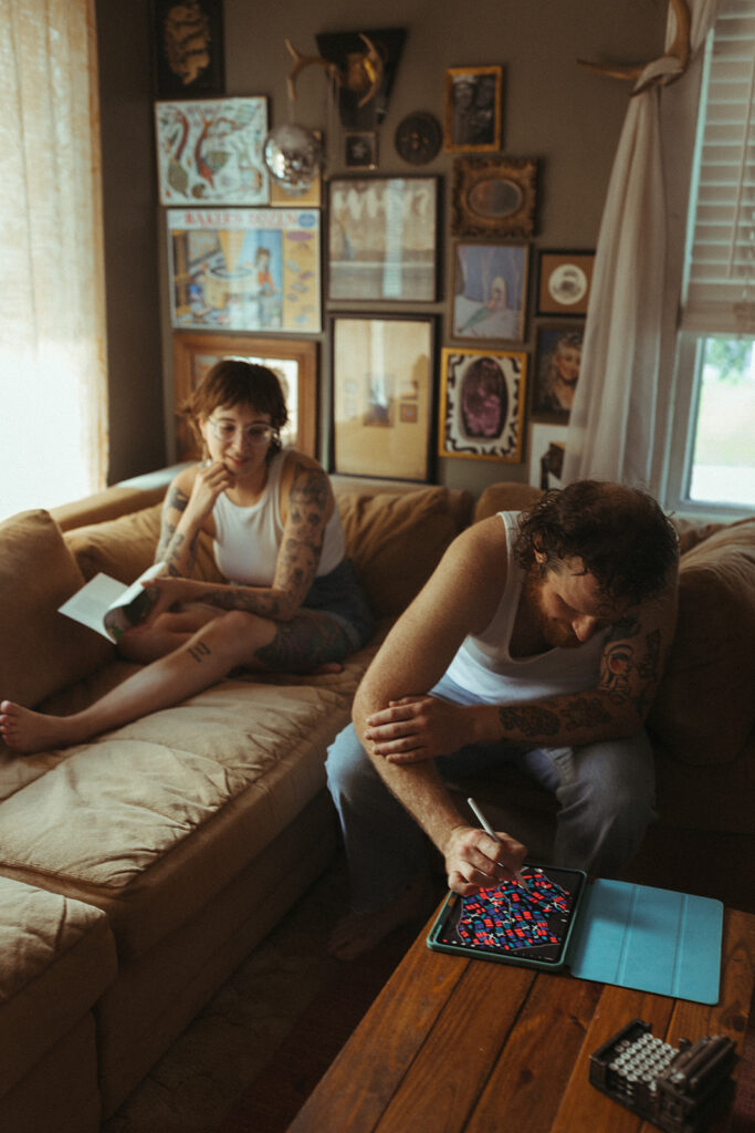 Man playing games while woman reads on the couch