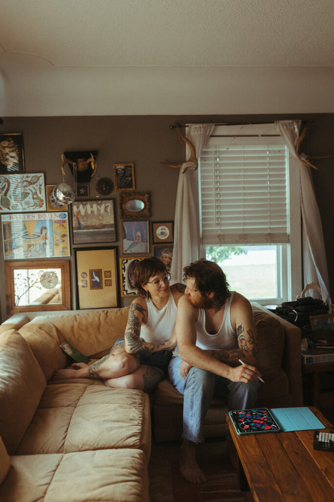 Man and woman sitting on their couch during their at-home Grand Rapids engagement photos