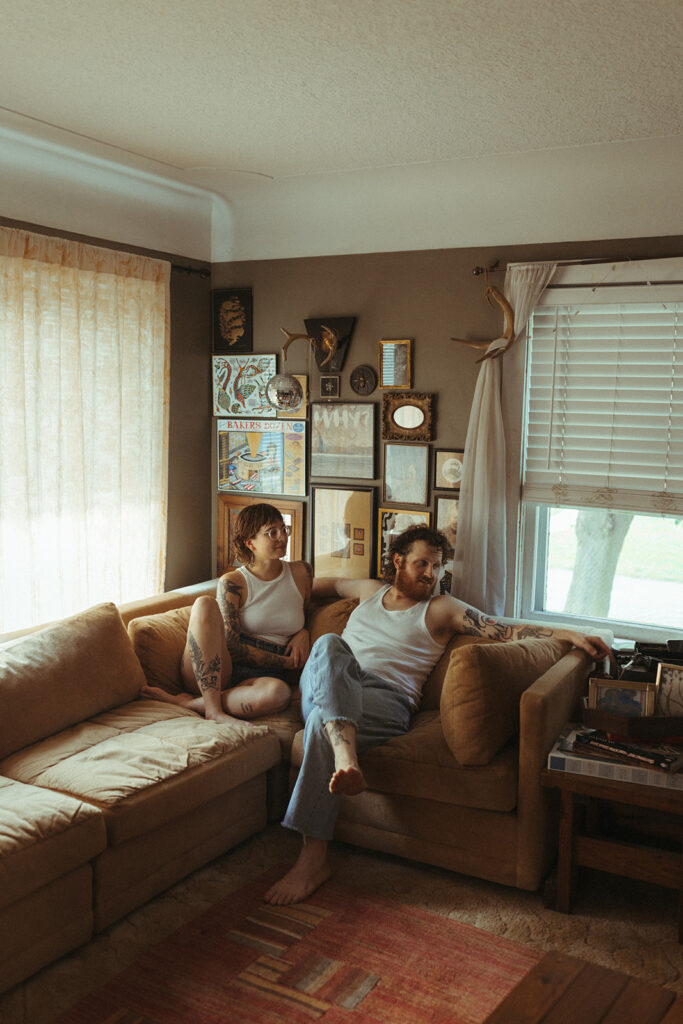 Man and woman sitting on their Midwest couch for their at-home couples session