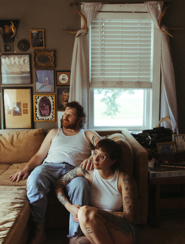 Man and woman sitting on their Midwest couch for their at-home couples session