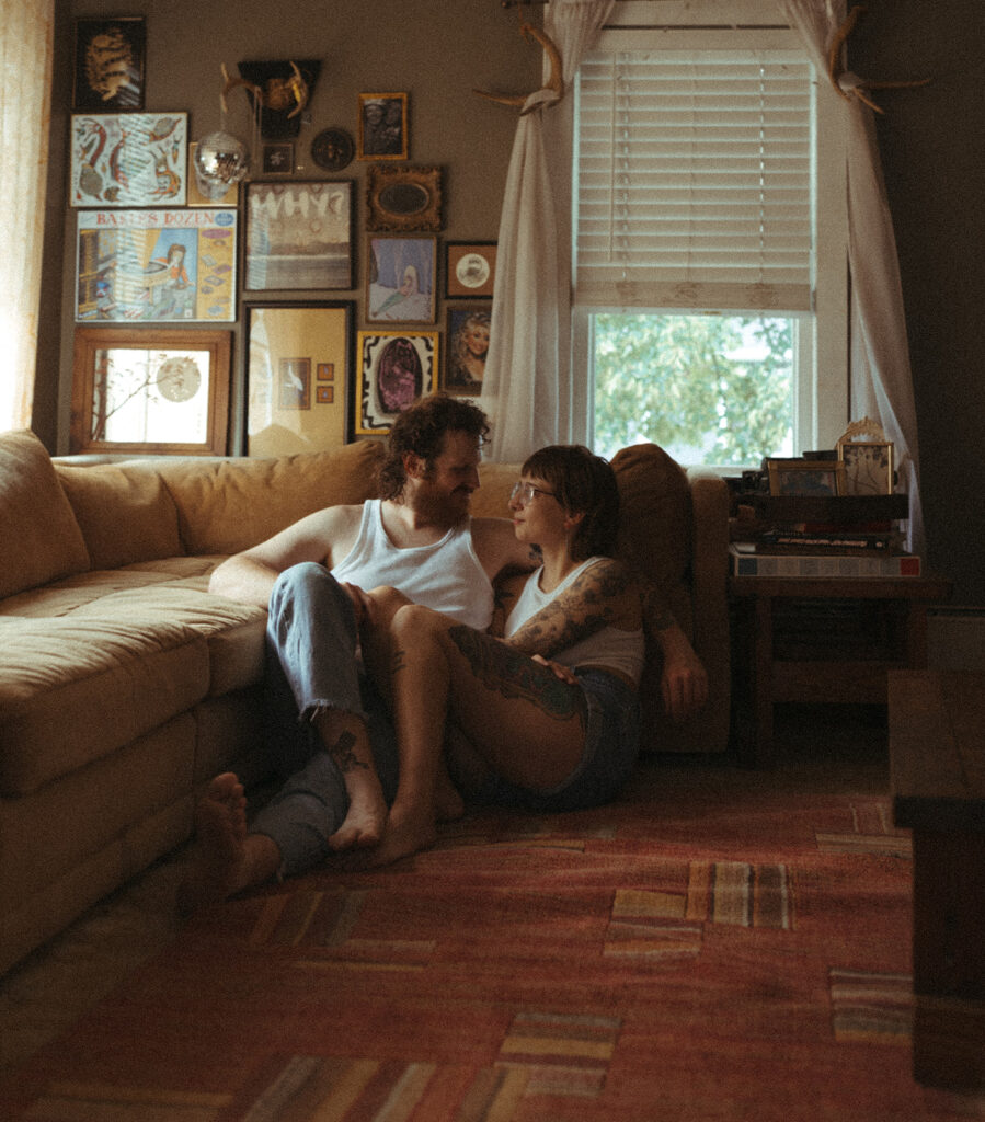 Man and woman sitting together on their living room floor for their Grand Rapids engagement photos