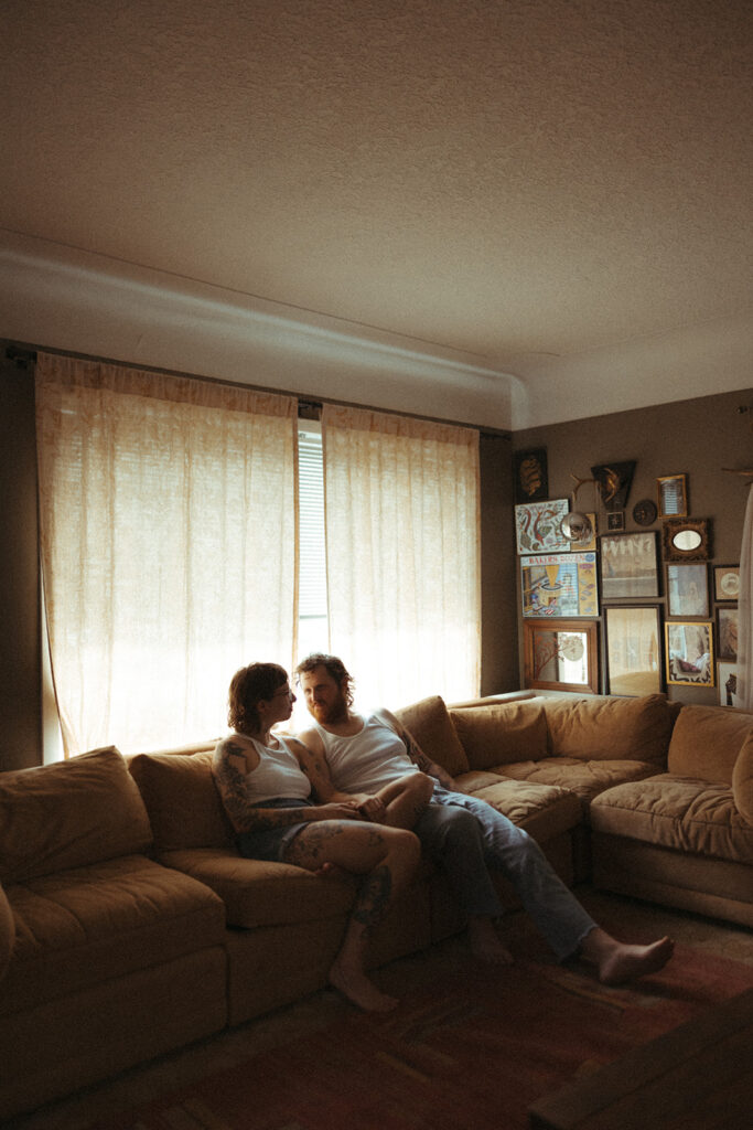 Man and woman sitting on their couch for their at-home Grand Rapids engagement photos