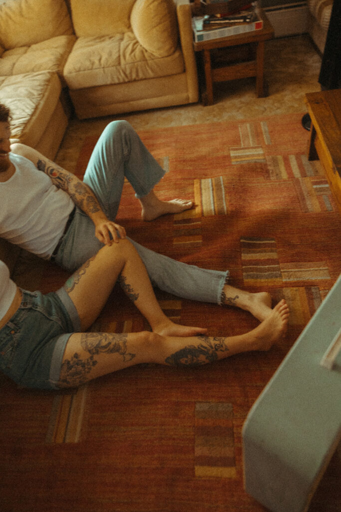 Man and woman sitting together on their living room floor