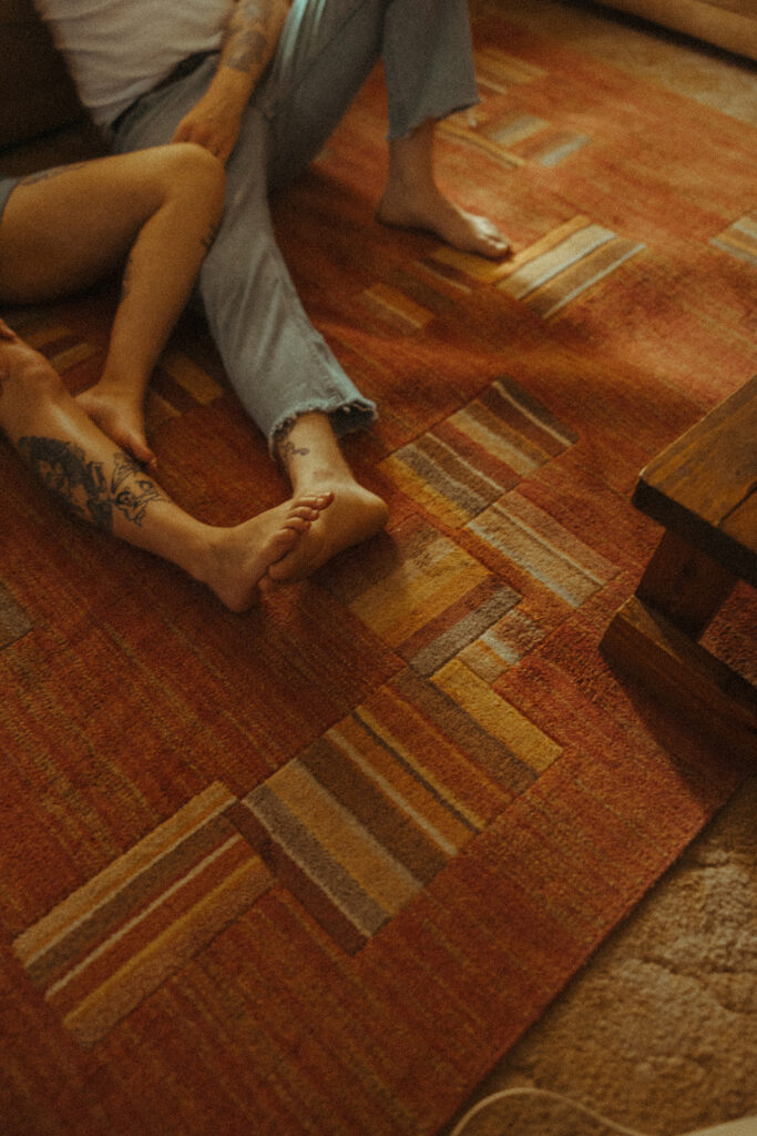 Couple sitting on their orange living room rug