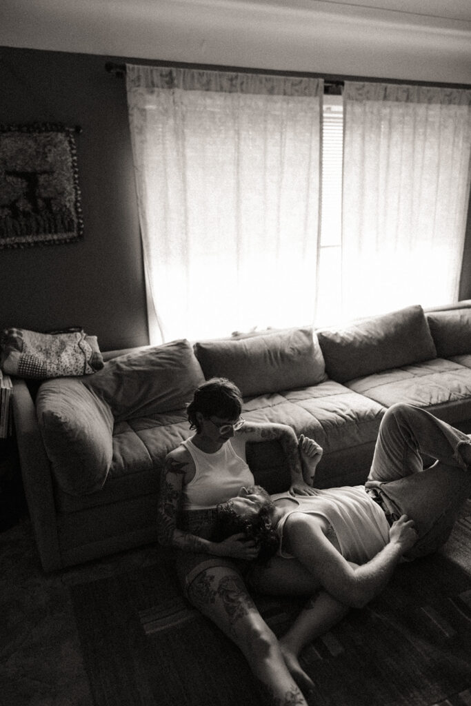 Man laying on his girlfriends lap during their at-home Grand Rapids engagement photos. 