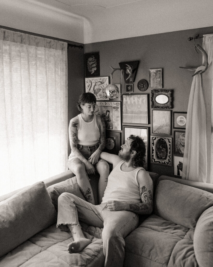 Black and white photo of a couple sitting on their couch for their at-home Grand Rapids engagement photos