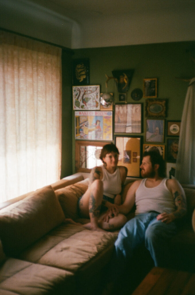 Couple sitting in their living room for their at-home Grand Rapids engagement photos captured on film