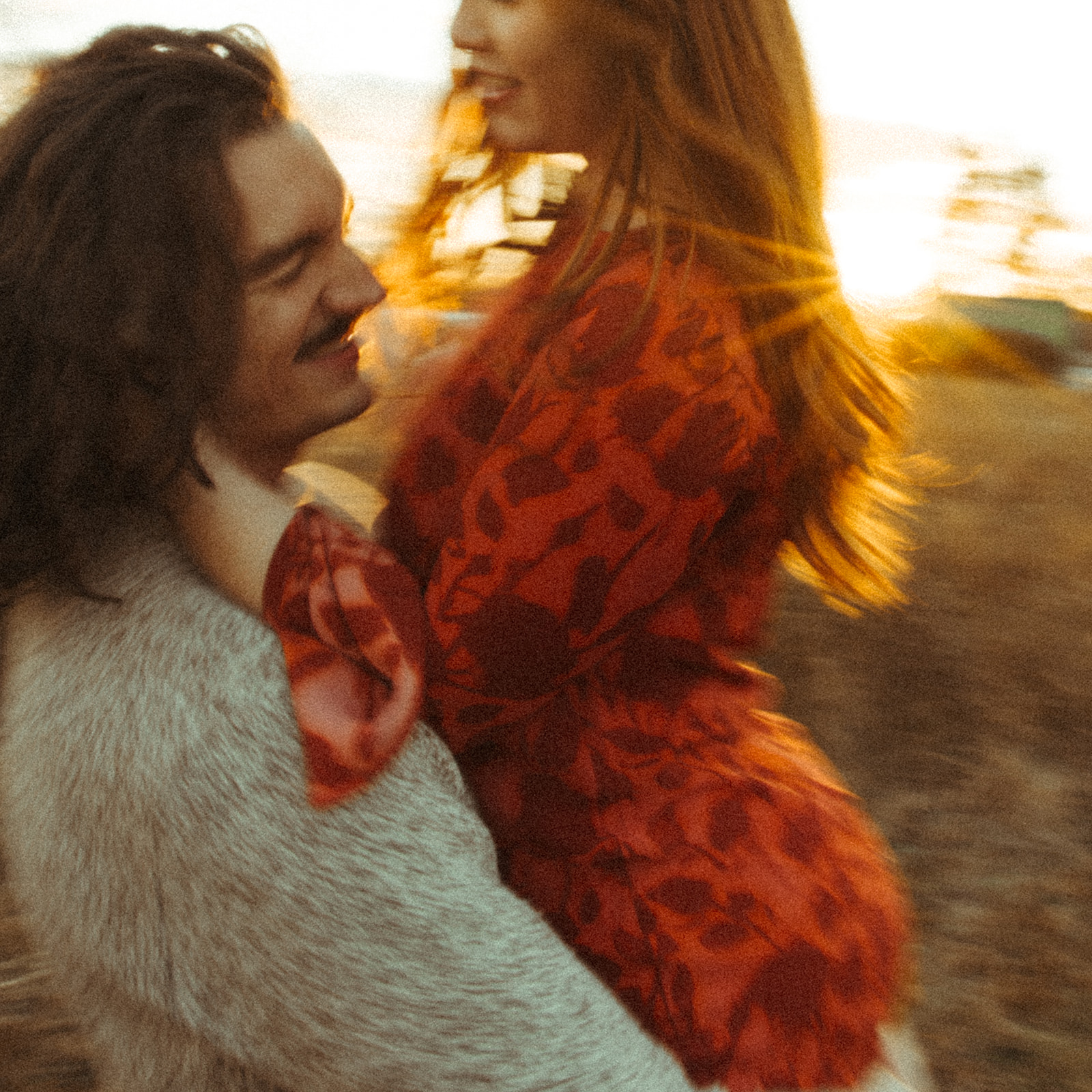 Man lifting up his fiancé during their fall sunset Belle Isle engagement photos in Detroit, Michigan