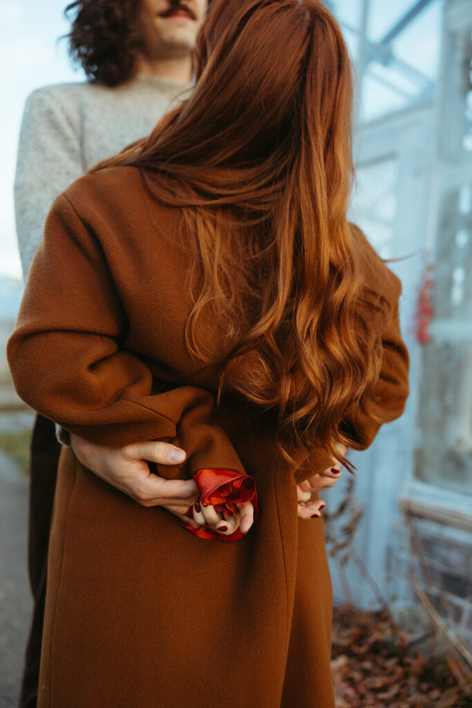 Man holding his fiancés waist during their fall Bell Isle engagement photos