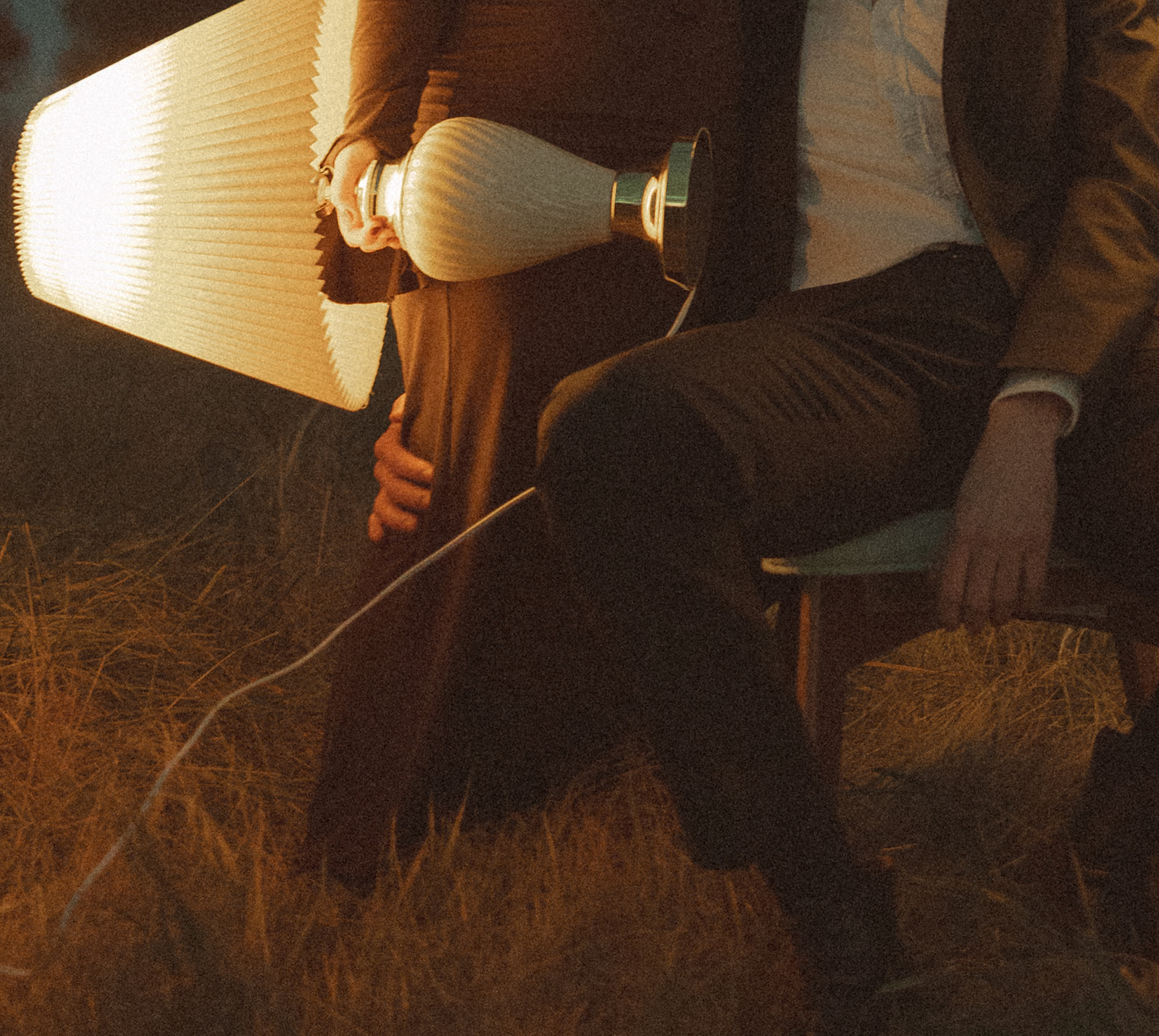 Close up shot of a couple holding lampshades during their outdoor field engagement session