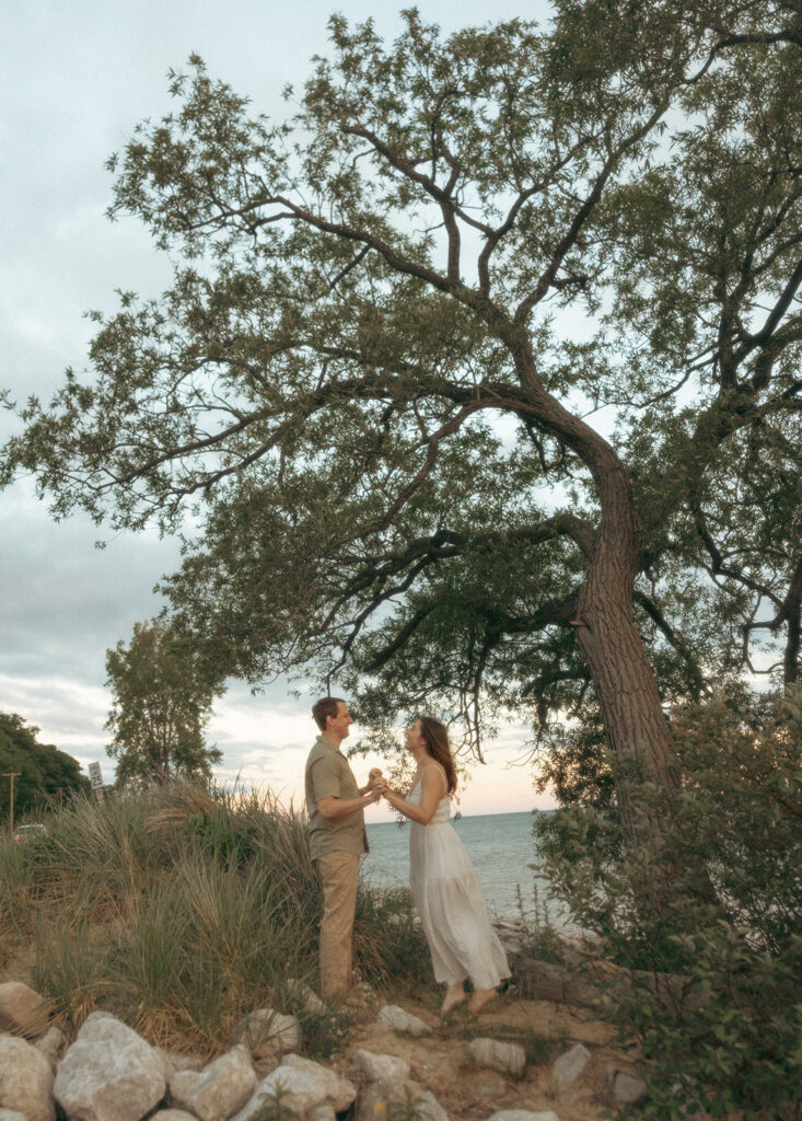 Couple holding hands during their Lake Michigan engagement photos