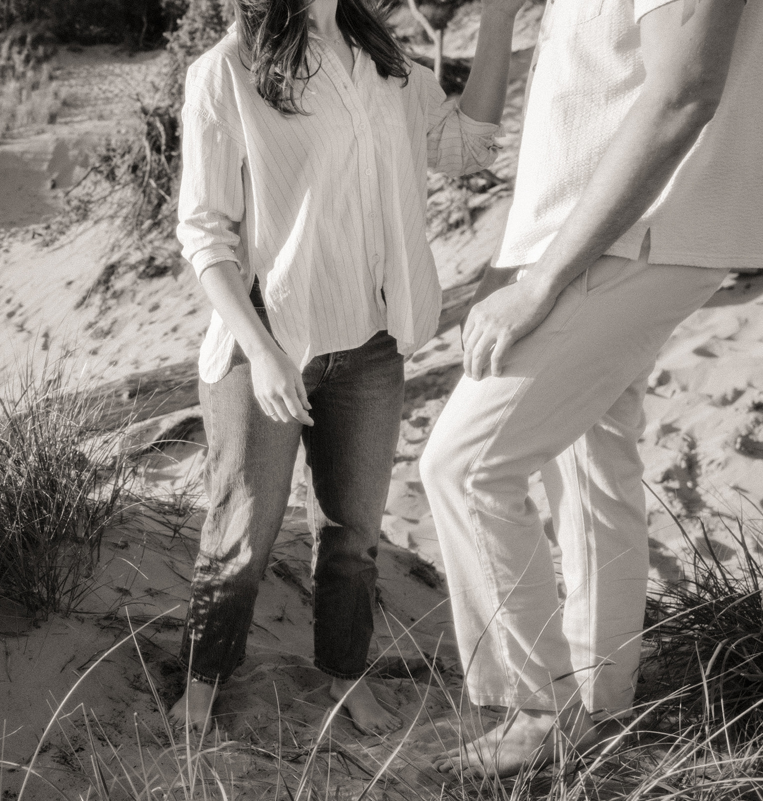 Black and white photo of a man and woman standing on the beach