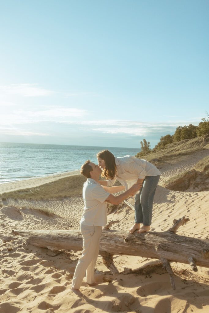 Man and woman kissing during their Lake Michigan engagement photos at Duck Lake State Park in Muskegon