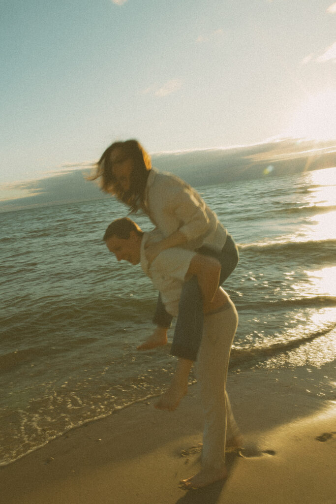 Couple having fun at Duck Lake State Park in Muskegon for their Lake Michigan engagement photos