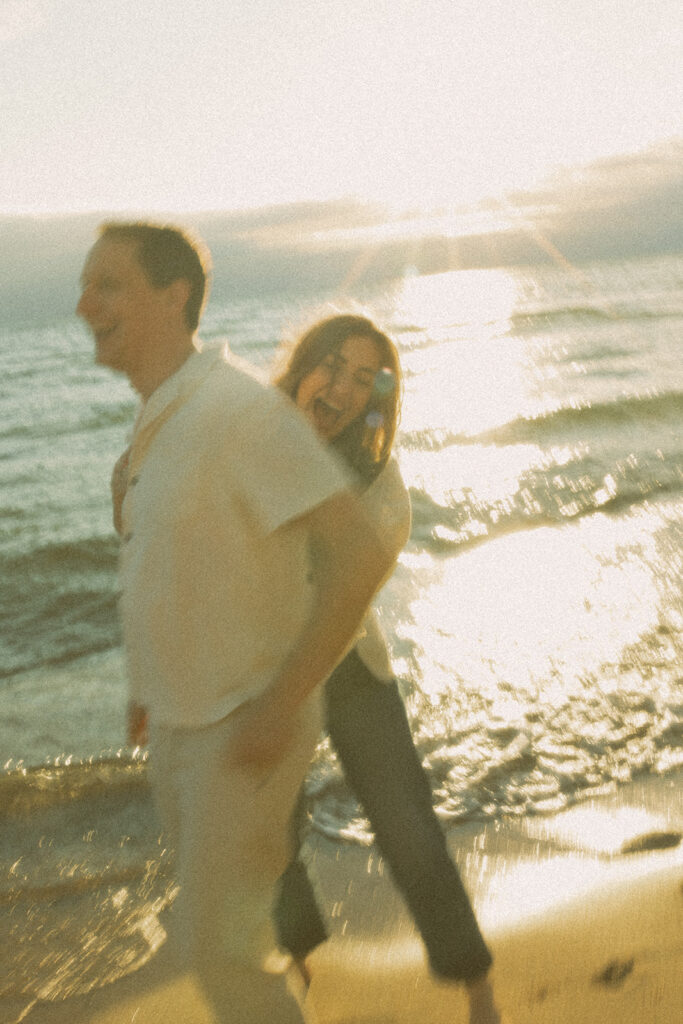 Candid engagement photos of a couple during their Lake Michigan engagement session at Duck Lake State Park in Muskegon
