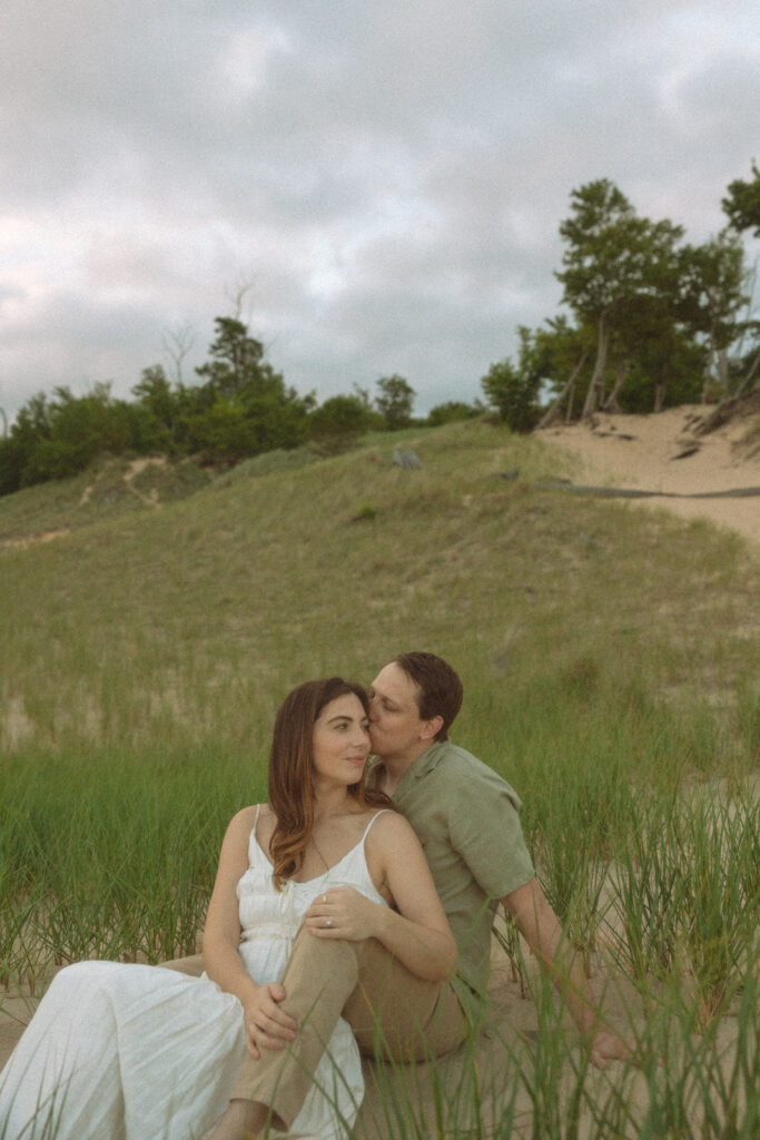 Couple sitting on the beach for their engagement shoot