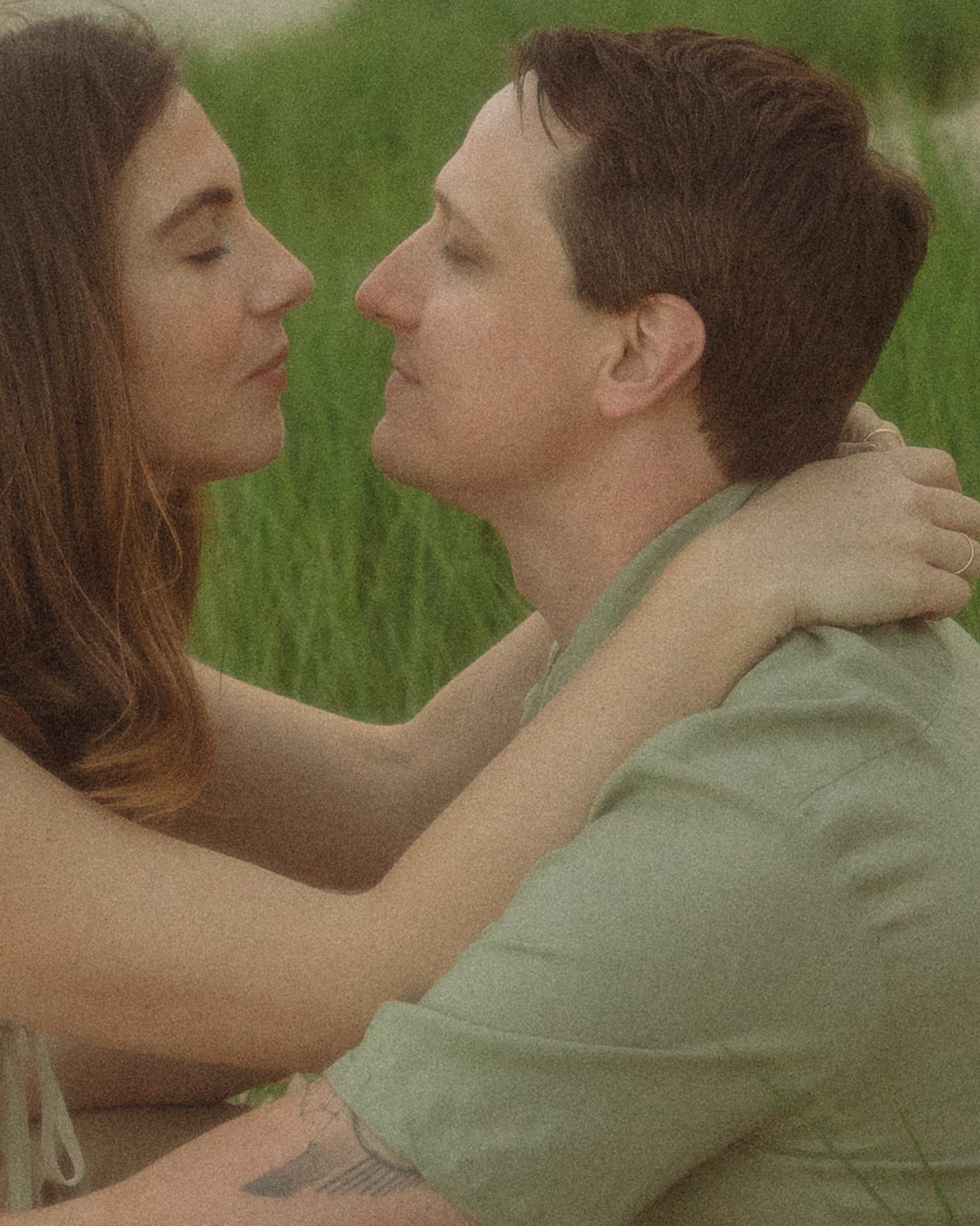 Close up shot of a couple sitting on the beach for their engagement shoot