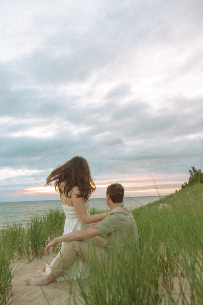 Couple sitting on the beach at sunset at Duck Lake State Park in Muskegon