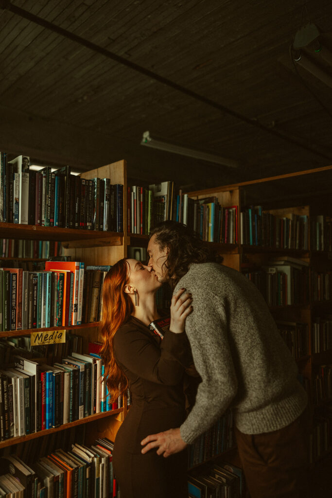 Couple kissing at John K King Books in Detroit, Michigan for their engagement session