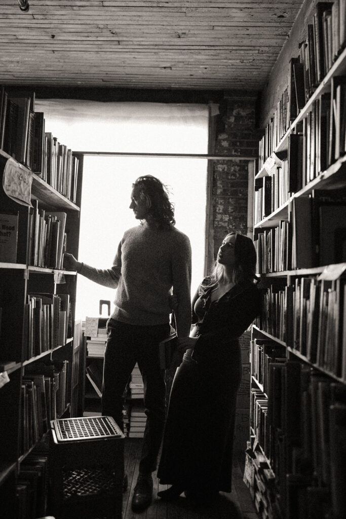 Black and white photo of a couple looking through books at John K King Books