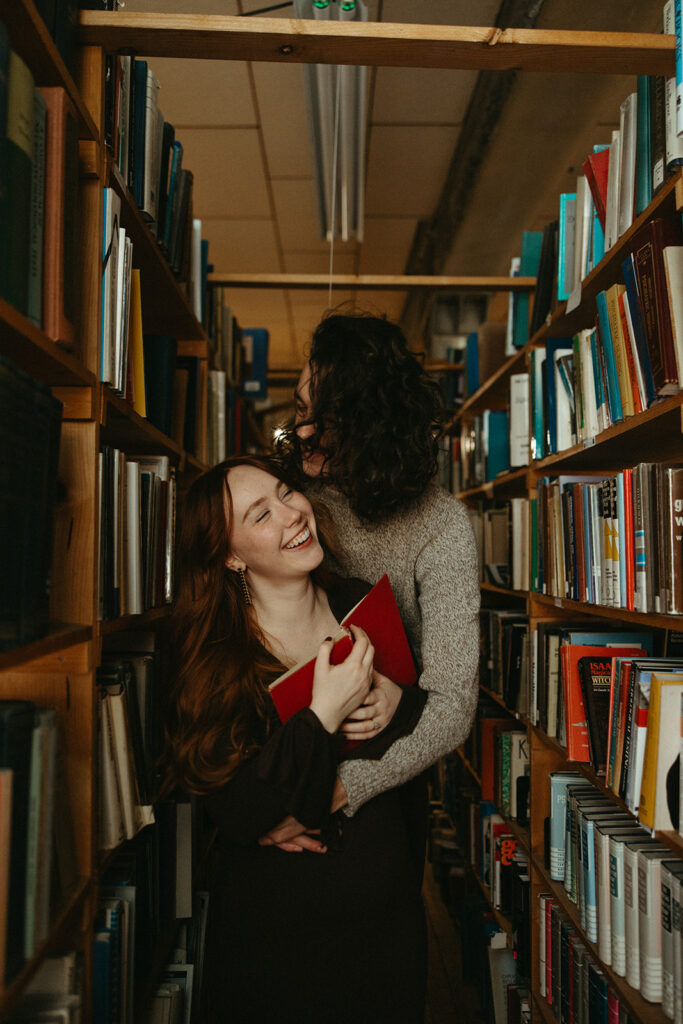 Man and woman being playful during their bookstore engagement session