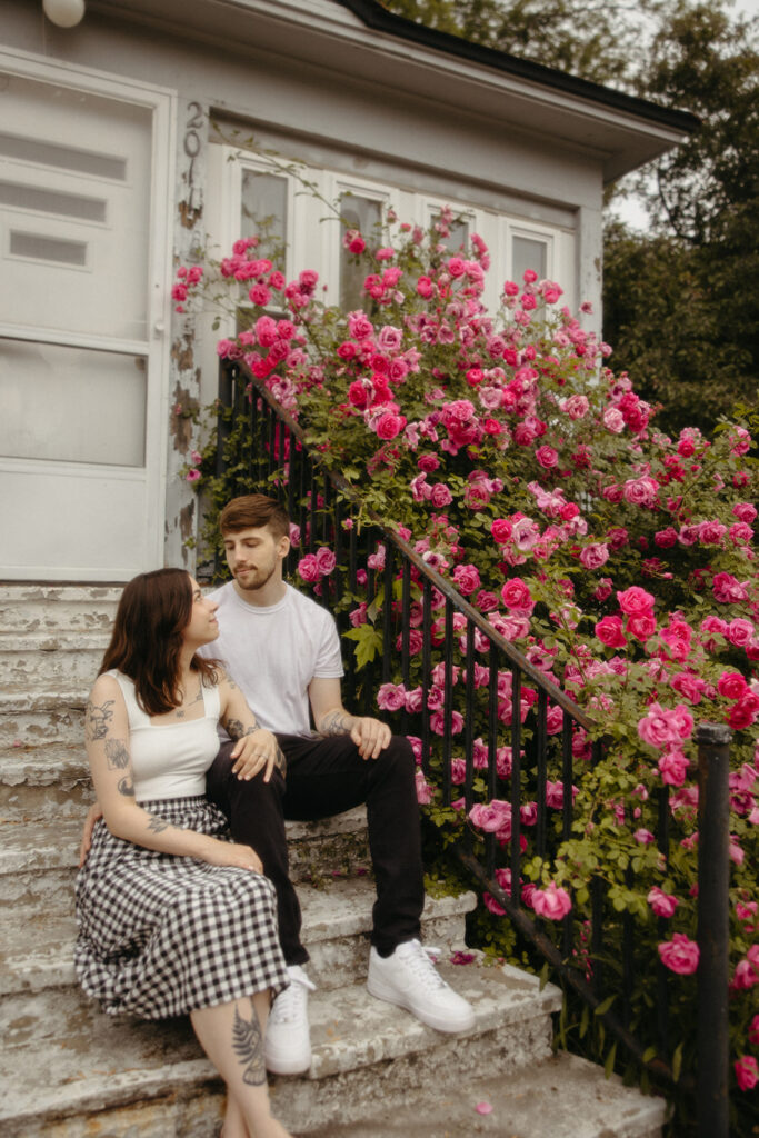 Couple sitting on a set of stairs during their summer engagement session