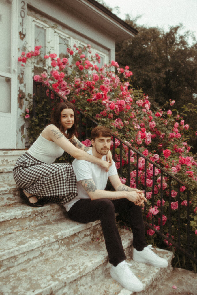 Man and woman sitting on a set of stairs during their summer engagement session