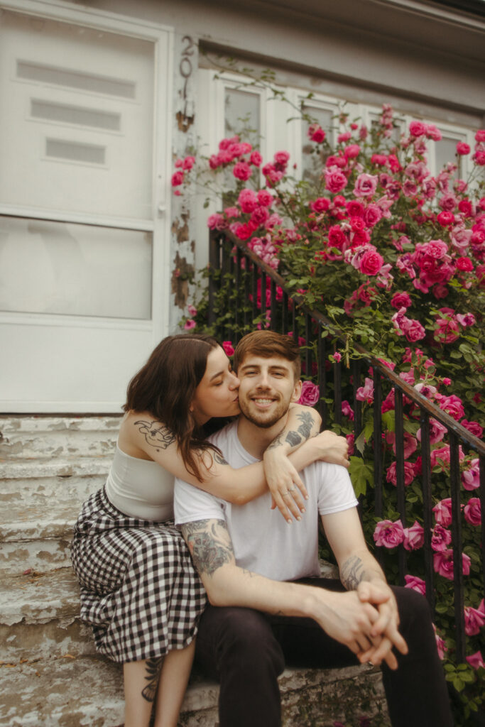 Woman kissing her fiancé on the cheek during their summer Bay City engagement photos