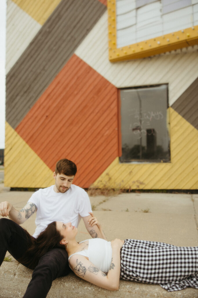 Woman laying down on her fiancé's lap during their downtown Bay City engagement shoot